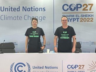 Woman and man wearing matching United Steelworkers union shirts are attending climate change negotiations in Egypt.